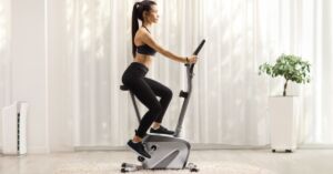 Kvinde på motionscykel i hjemmet