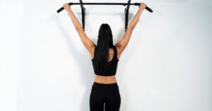 Kvinder træner med pull up bar i hjemmet
