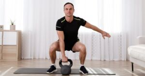 Mand træner med kettlebell hjemme